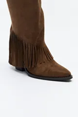 Bota texana de caña alta color beige confeccionada en gamuza, con punta fina, taco cuadrado de madera y detalle de flecos laterales. 