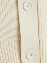 Cardigan de punto color crema con botones. Corte clásico y amplio.