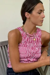 Top corto con estampado vichy en rojo y blanco, con breteles finos y detalle de fruncido en el escote.