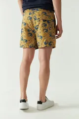Short de baño celeste con estampado de hojas, cintura elástica con cordón ajustable, dos bolsillos laterales y uno trasero.