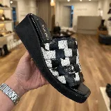 Zuecos con plataforma marrón y capellada tejida en damero blanco y marrón.