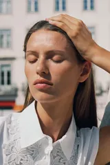 Camisa blanca de popelín con cuello solapa, manga sisa y detalle de guipur floral en el frente. Incluye un cinturón fino del mismo tejido que se ata en la cintura.