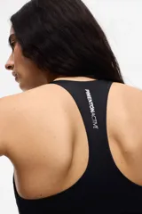 Top deportivo negro con escote en V, breteles finos cruzados en la espalda y copas removibles.