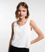 Musculosa lisa blanca de gamuza, con cuello redondo y sisas anchas.