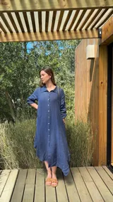 Vestido camisero amplio y largo de lino color azul, con botones de nácar, cuello camisero y bolsillos laterales.