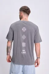 Camiseta manga corta oversize color gris oscuro con efecto lavado y estampado tribal en la espalda.