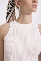 Musculosa negra de tejido de punto acanalado, con cuello redondo y sisas amplias.