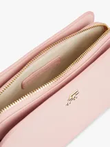 Bandolera Tommy Hilfiger color rosa con correa ajustable y logo dorado en el frente.