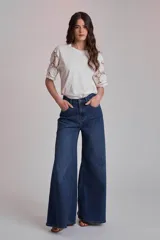 Remera blanca de algodón con mangas cortas de encaje floral.