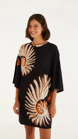 Vestido corto negro con estampado de espirales color crema y naranja, cuello redondo y mangas anchas.