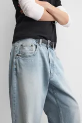 Pantalón de jean celeste con efecto lavado, corte amplio tipo baggy y cinco bolsillos.