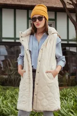 Chaleco largo puffer de nylon color beige, con dos bolsillos laterales y diseño ligero.