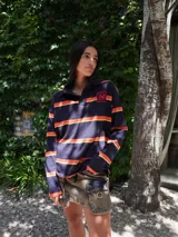 Buzo tipo rugby confeccionado en algodón a rayas horizontales azul marino, naranja y amarillo. Presenta cuello tipo polo y cartera en contraste con logo bordado en el pecho.