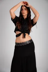 Camisa corta negra de manga corta con broderie en el frente y mangas. Se ata con un nudo en la parte delantera.