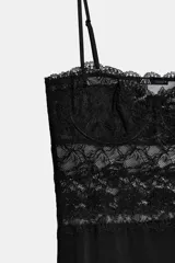 Vestido midi negro de tirantes finos, con corpiño estructurado y detalle de encaje negro en la parte superior.