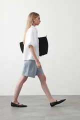 Bermuda de denim azul claro con rayas verticales blancas, de corte relajado y largo hasta la rodilla. Presenta pespuntes a contratono.