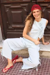 Pantalón negro de tejido ligero, corte holgado, cintura elastizada y aberturas laterales con lazos.