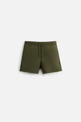 Short de baño verde militar con cintura elástica ajustable con cordón. Bolsillos laterales y trasero. Forro interior.