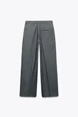 Pantalón ancho gris con textura de espiga, tiro alto, doble cintura elástica ajustable con cordón, pinzas frontales, bolsillos delanteros y falso bolsillo de vivo en la espalda.