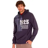 Buzo hoodie Caterpillar azul marino con capucha ajustable con cordones bicolor, bolsillo tipo canguro, puños y dobladillo acanalados. Estampado frontal con el año 1925 y texto alusivo a la historia de la marca. Logo de Caterpillar estampado en la manga izquierda.