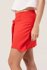 Minifalda roja con lazos para atar en la cintura y cierre en la parte trasera.
