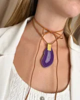 Collar con colgante de piedra agata color púrpura, con cordón de cuero marrón.