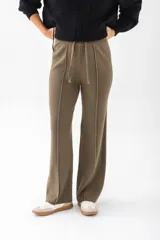 Pantalón de punto color beige, de corte palazzo y cintura con cordón ajustable.