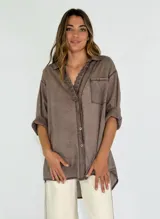 Camisa color naranja con cuello con detalle de puntilla, manga 3/4 y bolsillo en el pecho.