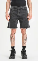 Bermuda de denim negra con efecto vintage, cinco bolsillos, calce regular y ruedo desflecado.