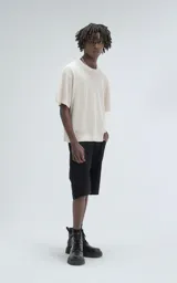 Remera de tejido de punto color beige con moldería ligeramente oversize, cuello redondo y mangas cortas. Confeccionada en una mezcla de viscosa y poliéster que ofrece una caída fluida y textura suave.