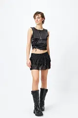 Minifalda negra de tul bordado con lentejuelas, cintura elastizada y volados en capas.