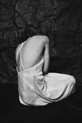 Vestido midi plateado confeccionado en hilo metalizado, con escote recto, tirantes finos y forro interior combinado.