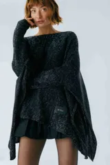 Poncho negro tejido en algodón, con moldería oversize y tajos en los laterales.