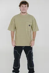 Remera color beige de corte holgado, con cuello redondo y bolsillo en el pecho.