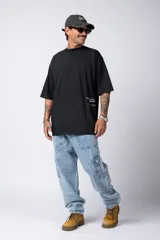 Remera negra de corte amplio con mangas cortas y estampado pequeño con texto en el frente.