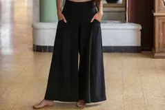 Pantalón palazzo negro de algodón con corte evasé, tiro alto, bolsillos laterales, elástico en la espalda y faja ancha.