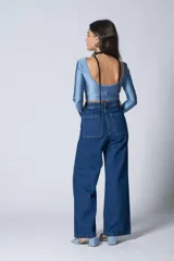 Top corto celeste de lycra, con escote redondo y mangas largas.