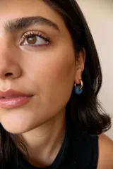 Aros de acero quirúrgico hipoalergénico con piedras naturales azules. Diseño de aro con dije circular colgante.