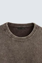 Sweater marrón de cuello redondo y manga larga, tejido con hilatura de textura bouclé y efecto lavado.