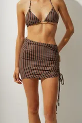 Minifalda de playa con estampado a rayas verticales azules y negras, con cordones laterales ajustables.