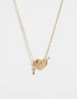 Cadena corta dorada con dije de corazón y llave de metal.