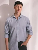 Camisa celeste de manga larga con cuello button-down, confeccionada en tejido rústico de algodón y lino.