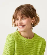 Blusa negra de manga corta con cuello redondo y textura de punto con patrón de corazones o escamas.