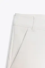 Shorts tiro bajo color negro con bolsillos delanteros. Cierre frontal con cremallera y ganchos metálicos.