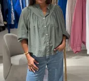 Camisa verde oliva de manga larga con puño, cuello mao y cierre frontal con botones.