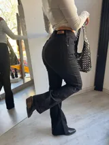Pantalón de jean negro, corte oxford y tiro alto.