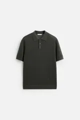 Polo de punto color verde oscuro, tejido en hilatura de algodón, de corte regular fit, con cuello solapa y cierre frontal de botonadura.