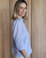 Camisa color beige claro con cuello con volados y mangas 3/4 abullonadas.