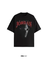 Remera negra de algodón con estampado frontal de Michael Jordan con gafas y el texto "Michael Jordan" en rojo.