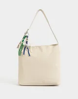 Cartera tipo saca color crudo, de cuerina, con asa corta regulable para el hombro y cierre superior. Incluye charms decorativos colgantes.